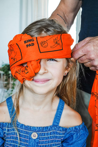Child wearing an orange eye wrap headband to protect impalement 