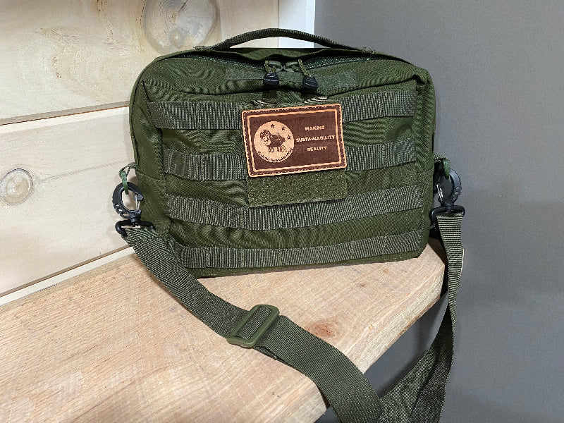 Green tactical bag with a patch on a wooden surface